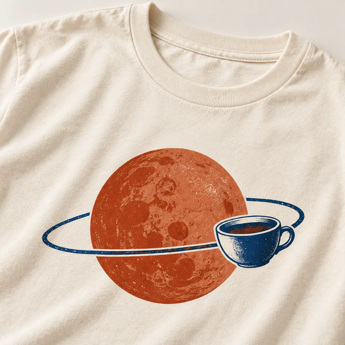 Detail mockup of a cream crew neck T-shirt in the Coffee Planet design